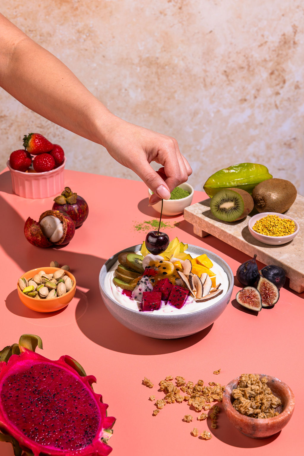 Hands preparing a fresh yogurt bowl with organic toppings.
